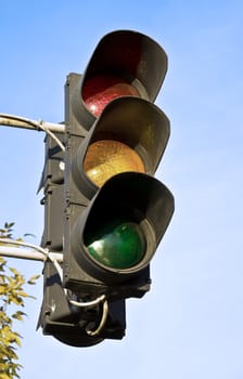 Old traffic light against the blue sky.