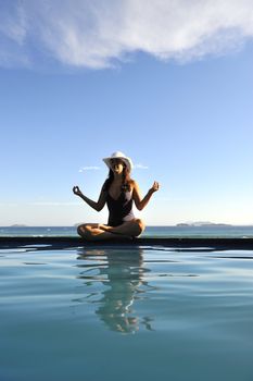 Woman relaxing on a swimming pool with a sea view
