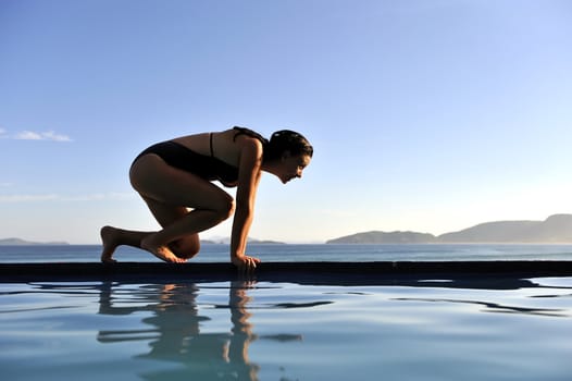 Woman relaxing on a swimming pool with a sea view 
