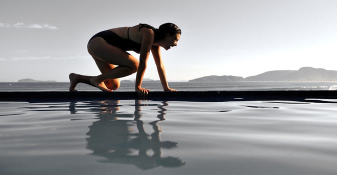 Woman relaxing on a swimming pool with a sea view 
