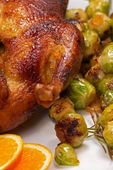 Roast duck in orange sauce served with brussels sprouts