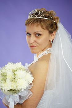 The bride looks at us - a portrait on a purple background