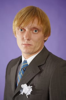 The groom looks at us - a portrait on the purple background