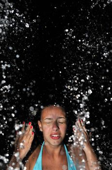 Beautiful swimsuit model splashing water on vacation
