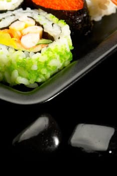 fresh assorted colorfull sushi plate over black