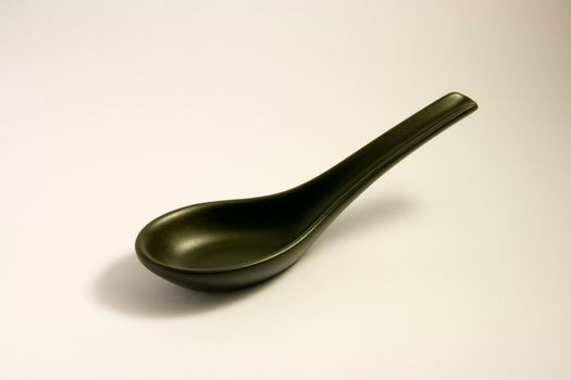 Black chinese china soup spoon on a white background
