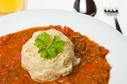 hungarian goulash and a bread dumpling on a white plate