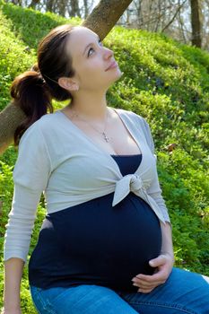 Calm pregnant woman enjoying spring outdoor nature