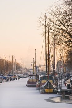 Evening light over frozen harbour on winter day in january