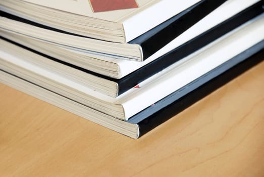 black and white magazines  pile closeup on wooden desk