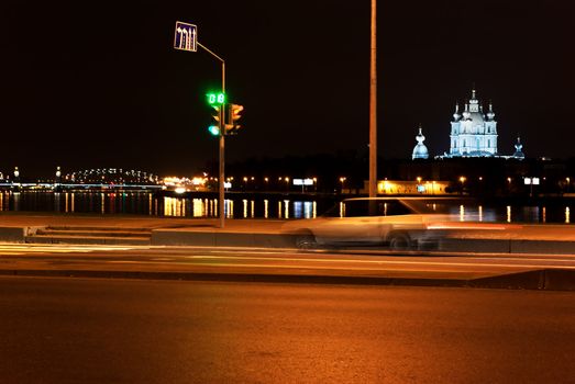 Car passes on the red signal of a traffic light on quay