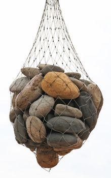 a group of stones in a net bag, hanging.