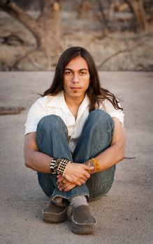 Handsome young man with long hair in an outdoor setting