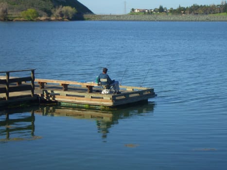 Fisherman fishing on a shore on a sunny day.