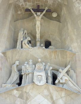 Statues and Jesus Christ on the cross at the entrance of the Sagrada familia church in Barcelona, Spain