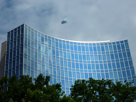 Modern office building with a onu flag upon by cloudy weather