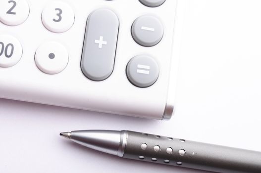 adding up figures concept with modern white calculator in office