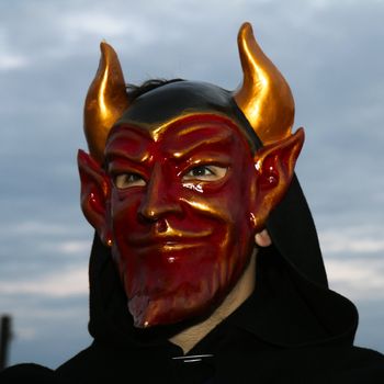 A masked man, dressed as devil at the Venice Carnival