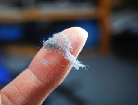 dust and finger showing cleaning concept with bokeh copyspace