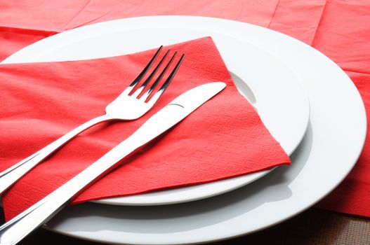 stainless fork knife and plate set on a table
