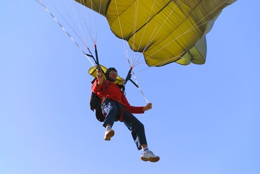 Parachutist pulling brakes of a green parachute.