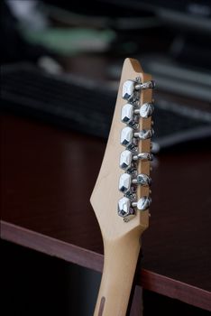 Electric guitar standing at a desk in a room