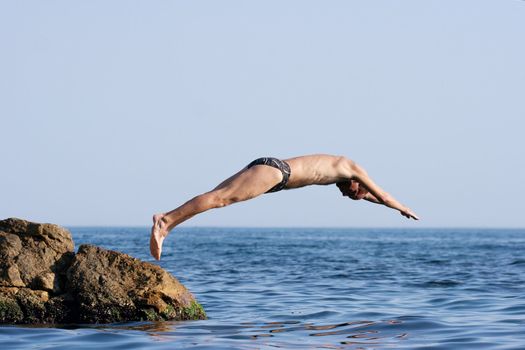 Man jumping headlong into the see