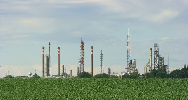 Oil refinery over a green agricultural field