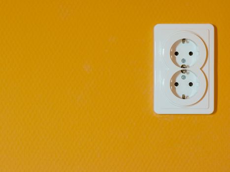 electric outlet socket on orange wall
