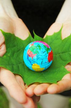 globe and leaf in hands for environmental conservation