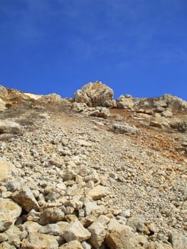 Tall mountain on a sunny day over blue sky.