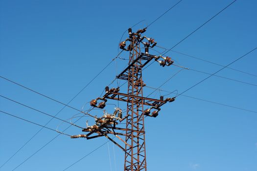 Old, rusty electric pillar under blue sky