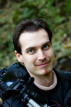 Nature photographer with his camera and tripod