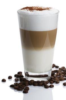 latte macchiato with cocoa powder and coffee beans on white background