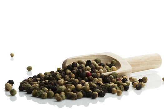 mixed peppercorns with a wooden shovel on white background