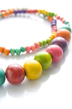 Colorful wooden necklace with vibrant colors and reflection.