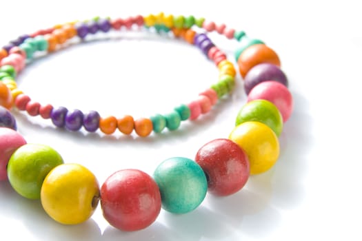 Colorful wooden necklace with vibrant colors and reflection.