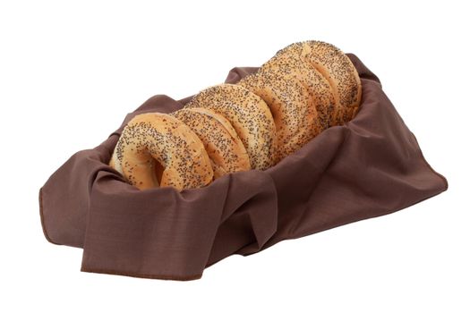 poppy seeds bagels in a basket with brown fabric napkin