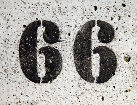 Number 66 painted on a concrete surface