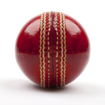 A Close-up shot of a red Cricket ball on white background.