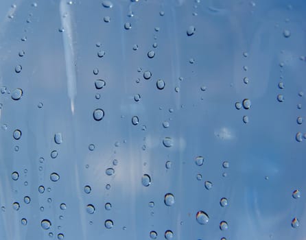 Many small droplets on a transparent blue surface