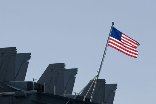 The stars and stripes flying from the back of the aircraft carrier kitty-hawk