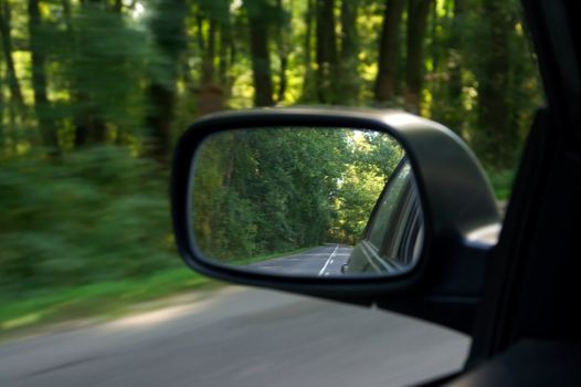 Sideview mirror of a car driving on the road