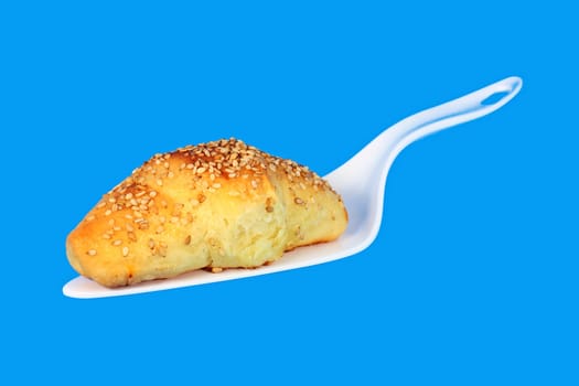 Hot fresh baked pastry with sesame seeds isolated on blue