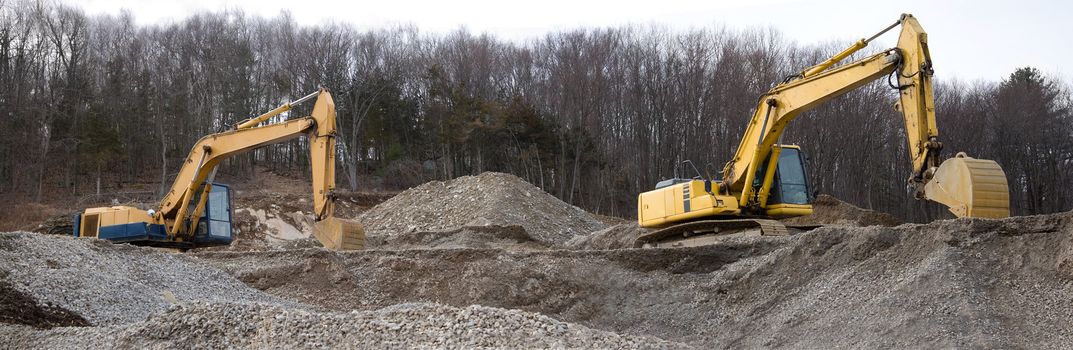 A panoramic view of a construction site with large earth movers.