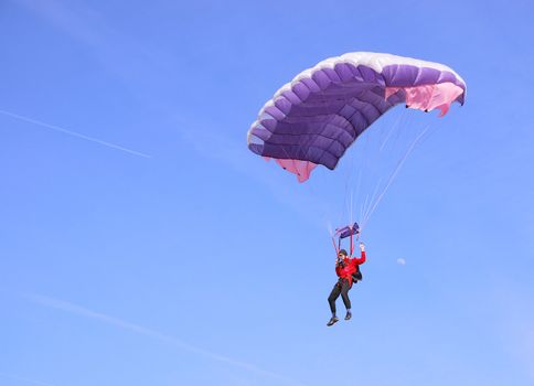 A purple parachute in a blue sky on a sunny day