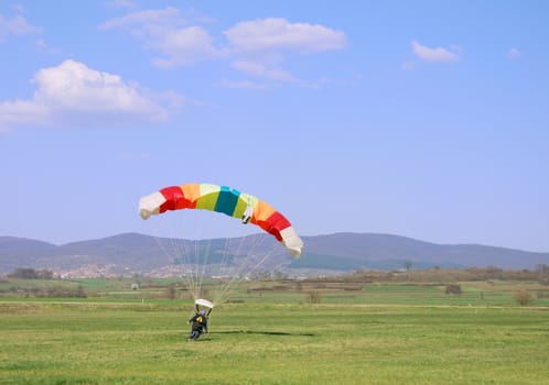 Parachutist landed on a field after good flight.