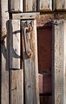 Fragment of an old wooden door with a handle. Close-up, front.