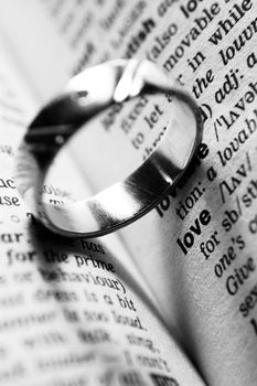 wedding ring near dictionary entry word love in black and white
