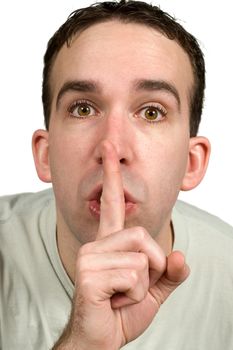 Closeup view of a man holding his finger to his lips expressing that he wants quiet, isolated against a white background